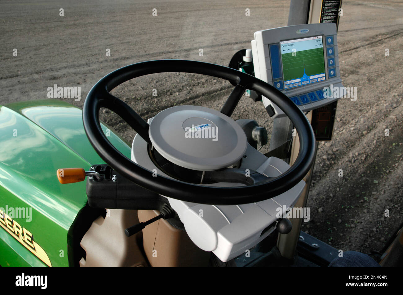 A tractor driver with GPS navigation for accurate field grading Stock