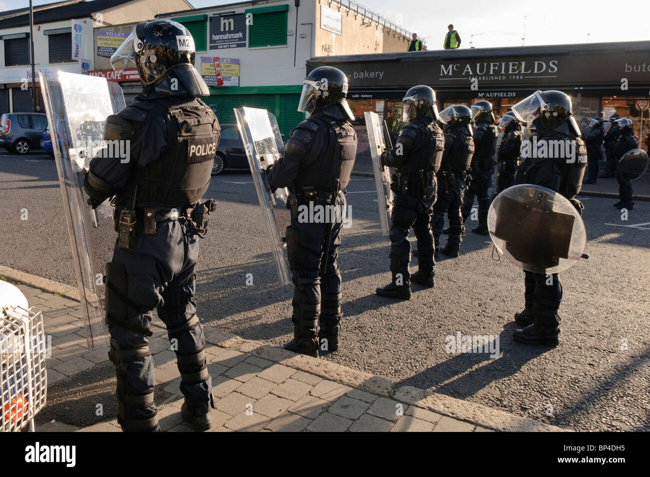 Police riot squad line up across a road in preparation for civil Stock