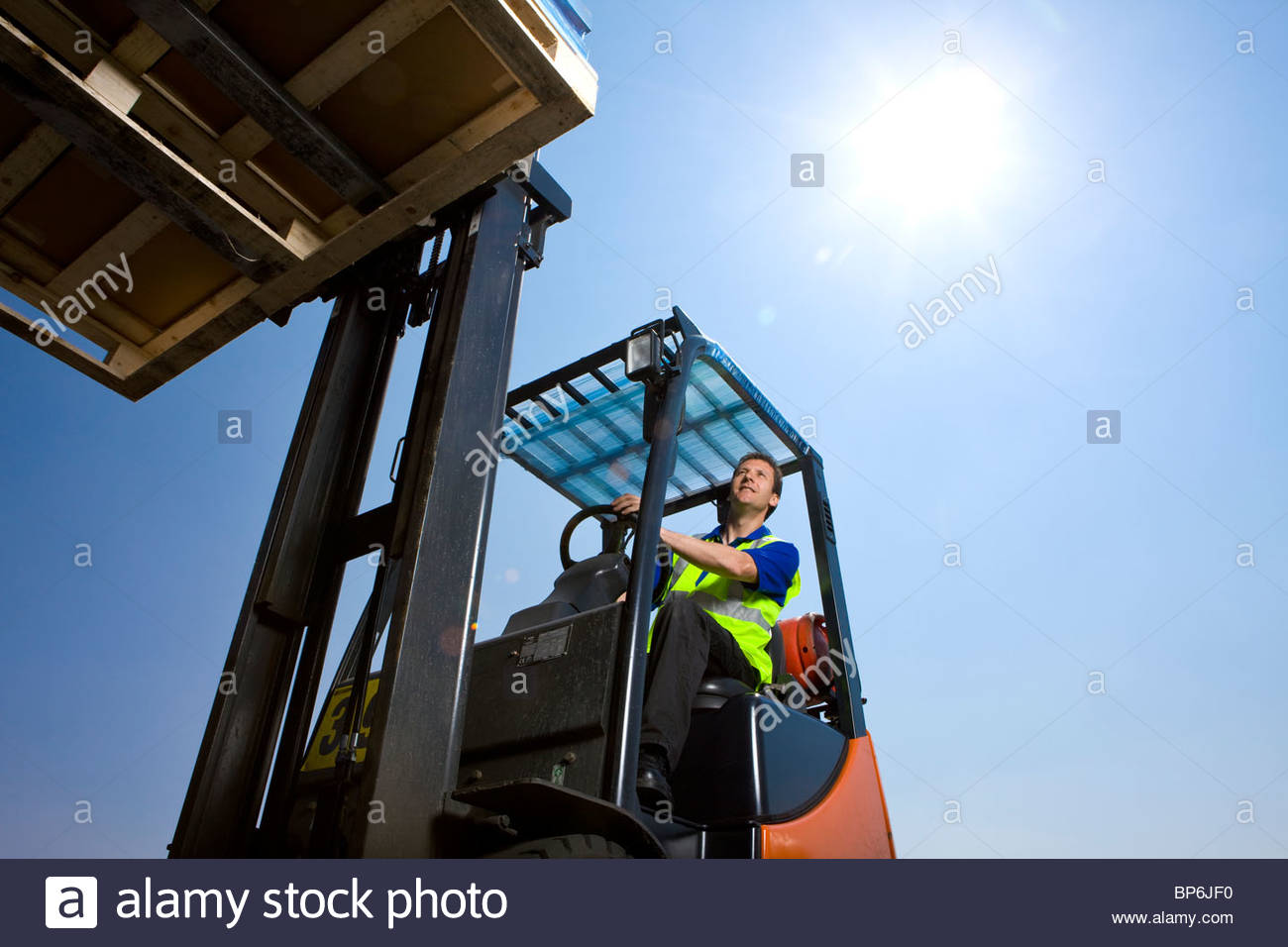 Worker driving forklift moving inventory Stock Photo, Royalty Free
