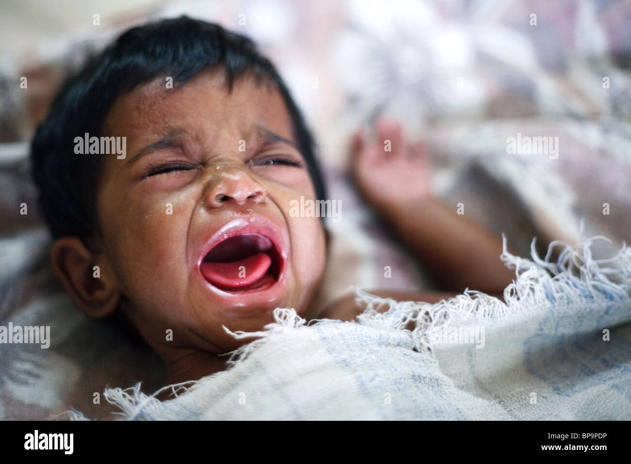 A little child cries loud in an orphanage for orphans and AIDS Stock