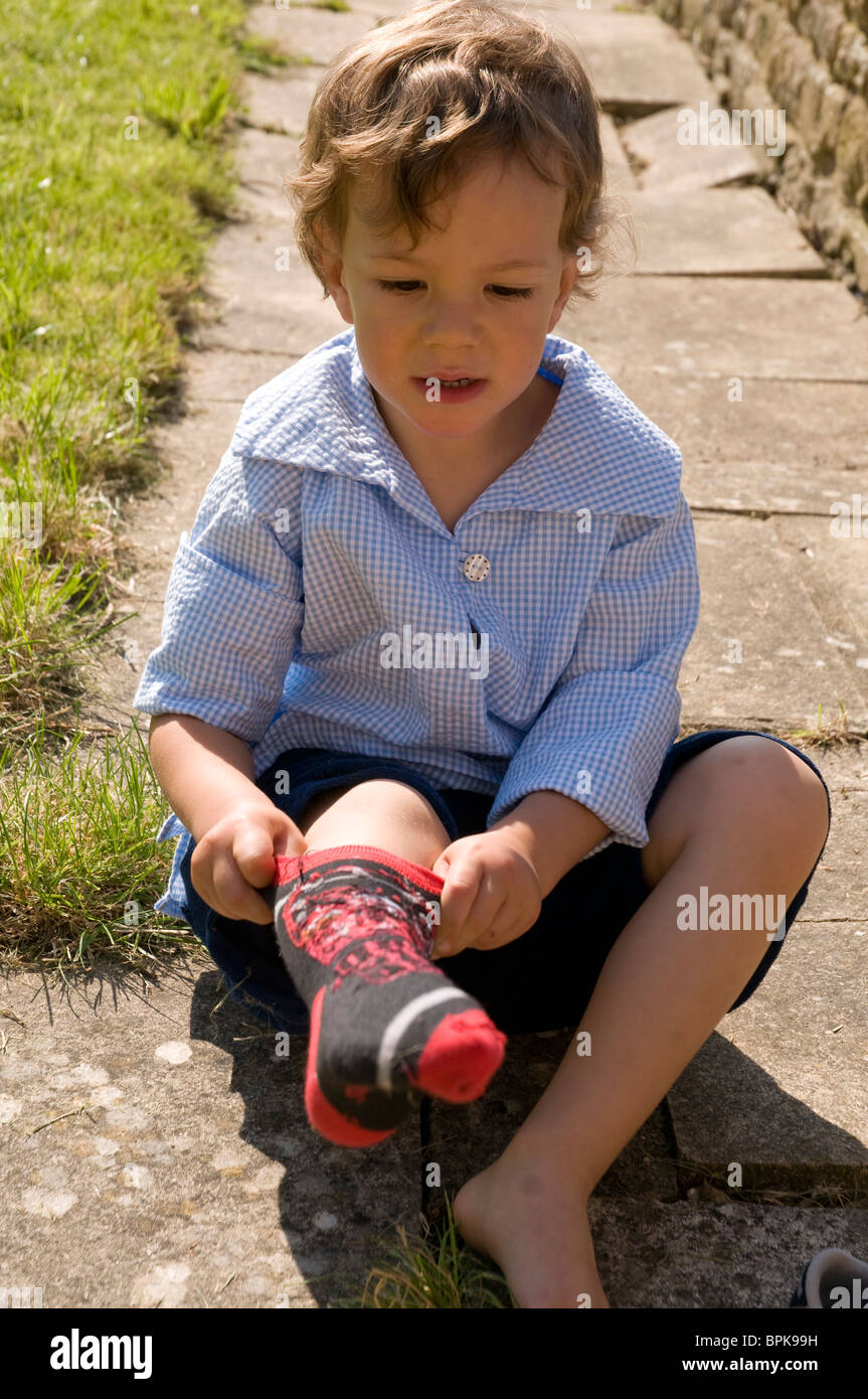 Little boy putting on a sock Stock Photo, Royalty Free Image 31157213