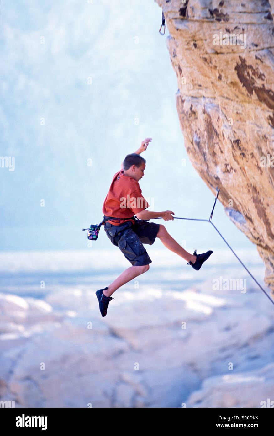 A young male rock climber falling / rock climbing on an overhanging