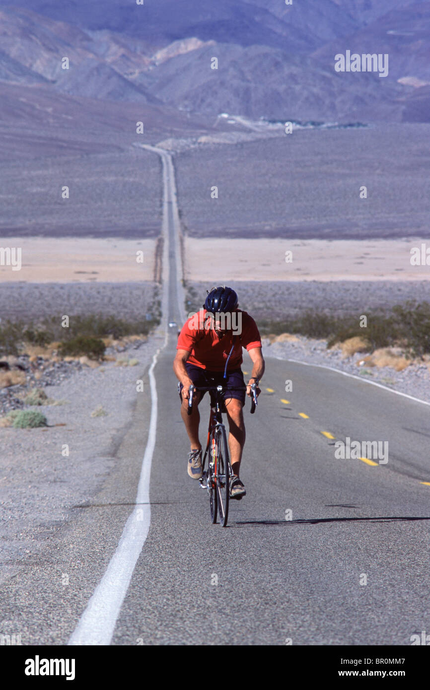 a-man-biking-uphill-in-the-desert-on-a-l