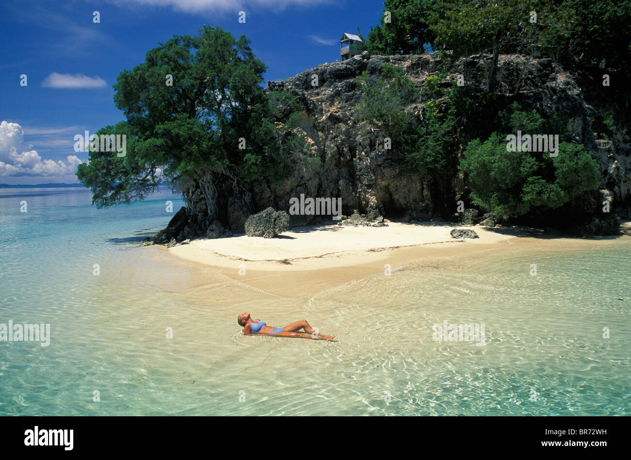 Woman relaxing off the southern tip of Walea Island, Tanjung Kramat