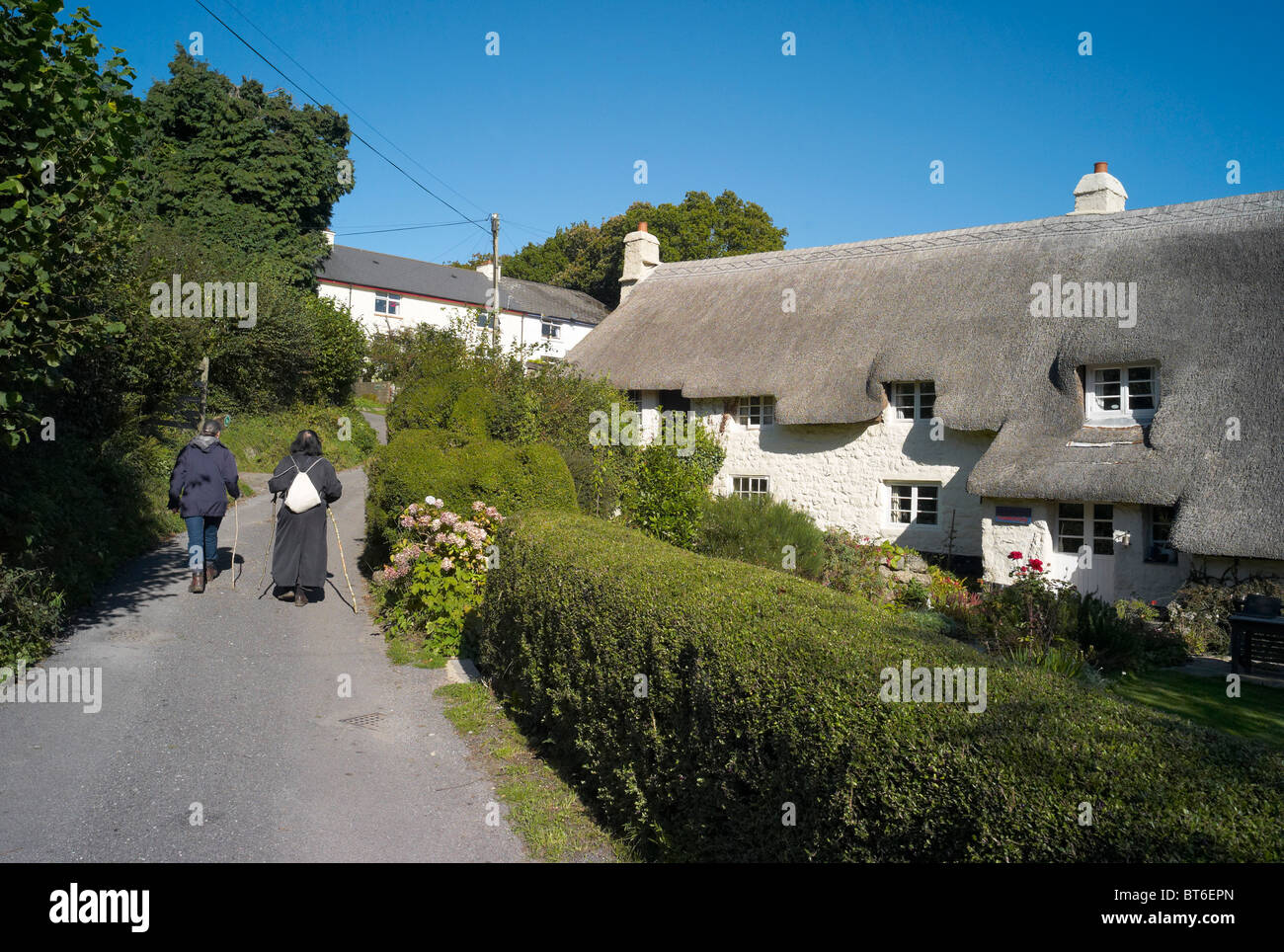 Walkers and thatched houses in the village of Pethybridge dartmoor