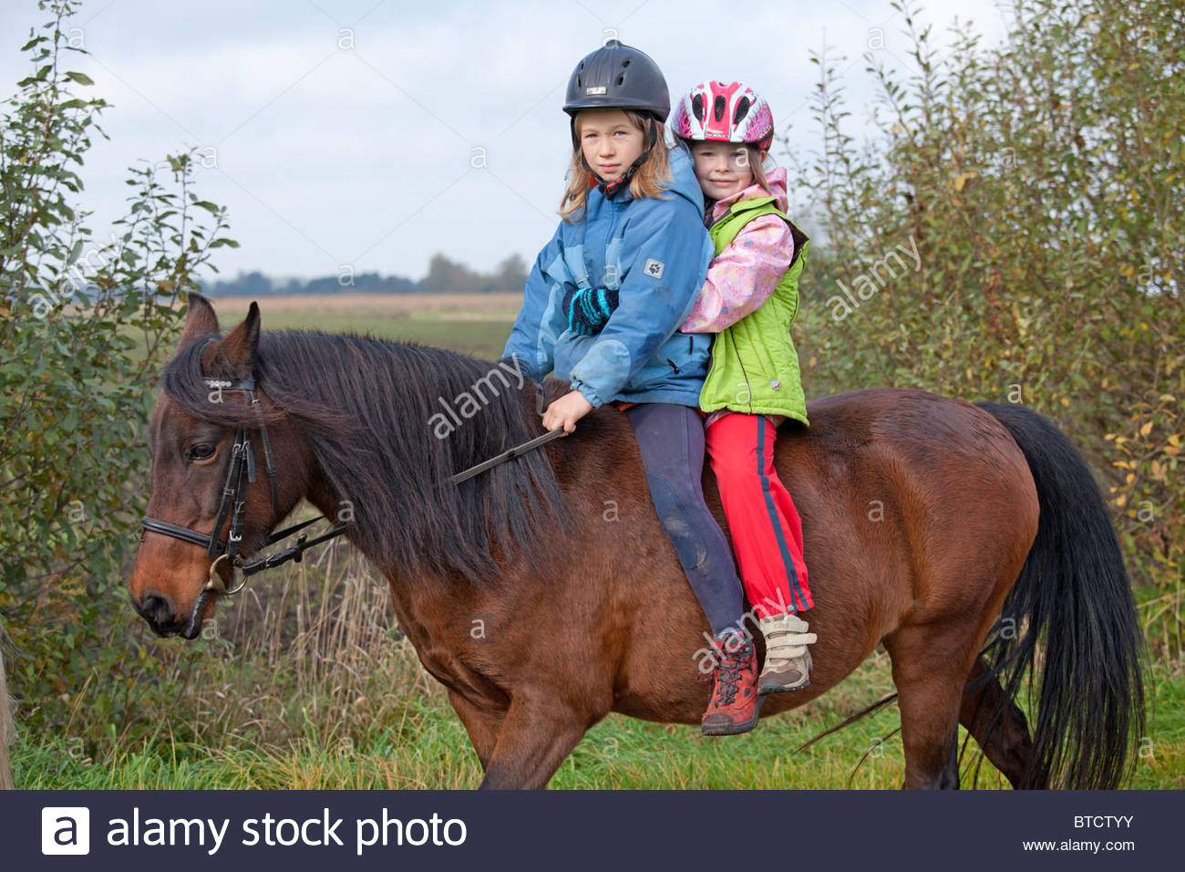 two small girls riding a pony together Stock Photo, Royalty Free two small girls riding a pony together Stock Photo, Royalty Free