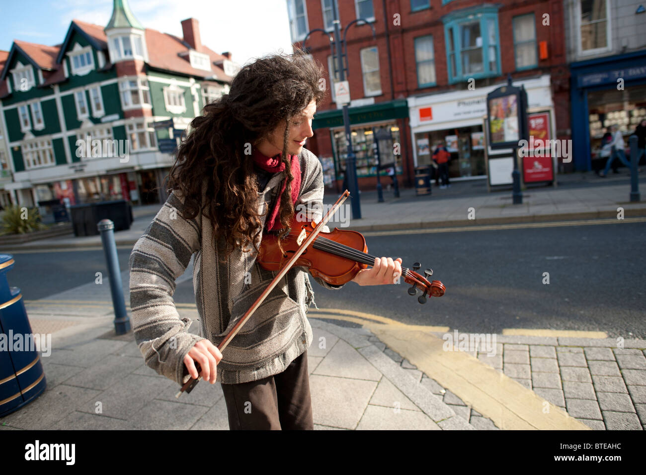 a man busking in the street playing the violin in the a man busking in the street playing the violin in the