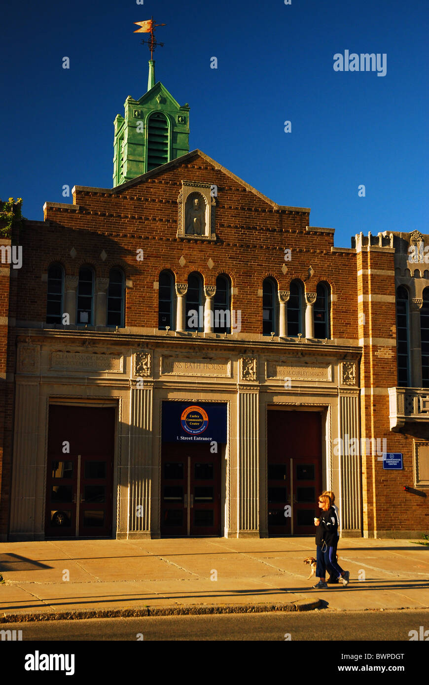 Two women walk past the historic L Street Bathhouse in South Boston
