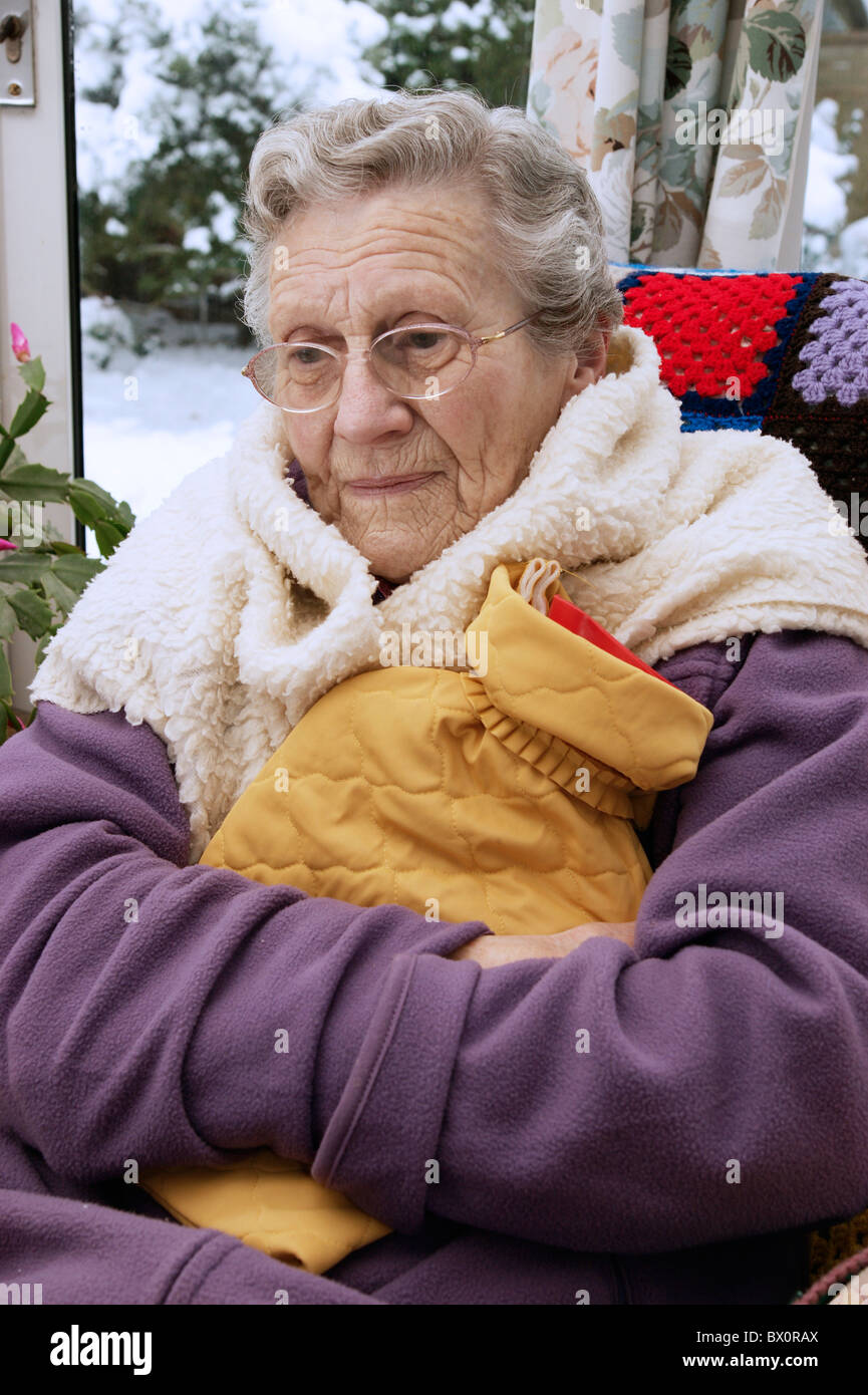 elderly woman keeping warm in winter wrapped up with a fleece blanket
