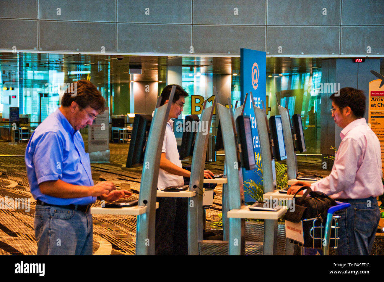 Remote computer kiosk station inside of lobby at Changi airport Stock