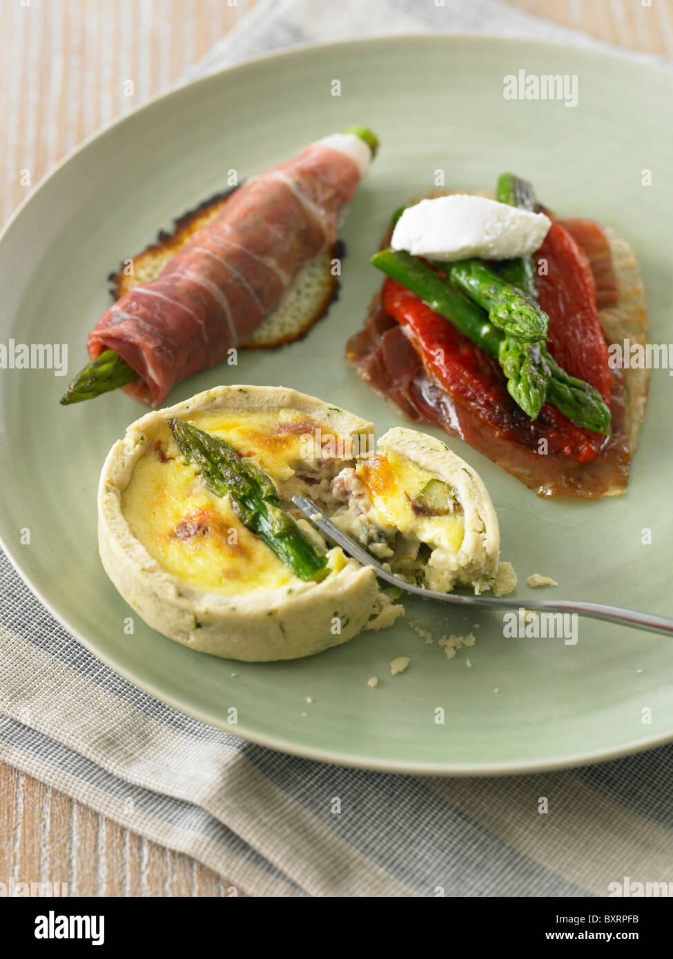 Trio of starters on plate, asparagus wrapped in smoked parma ham Stock