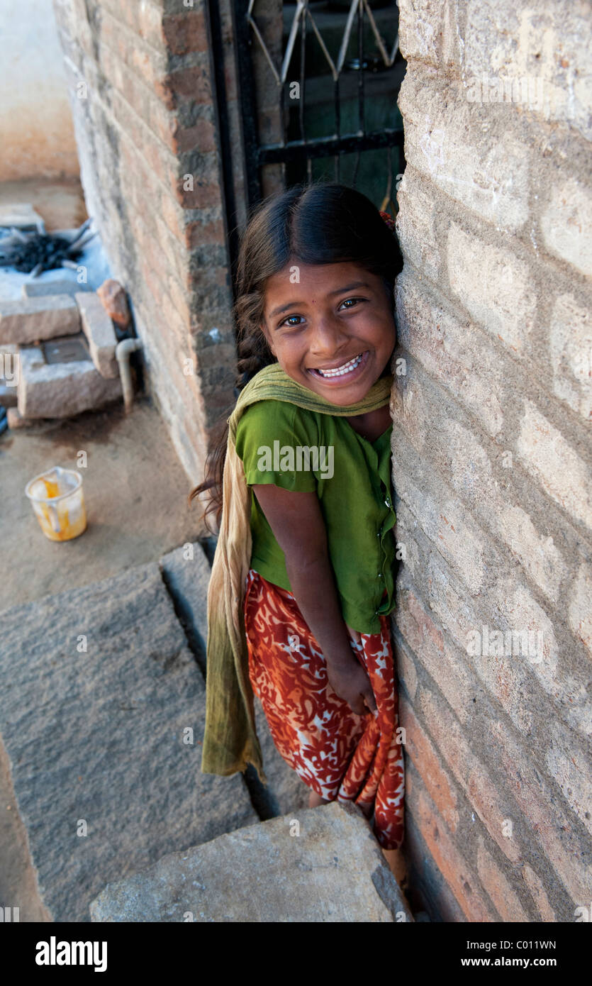 Smiling happy Indian village girl in the doorway to their house Stock
