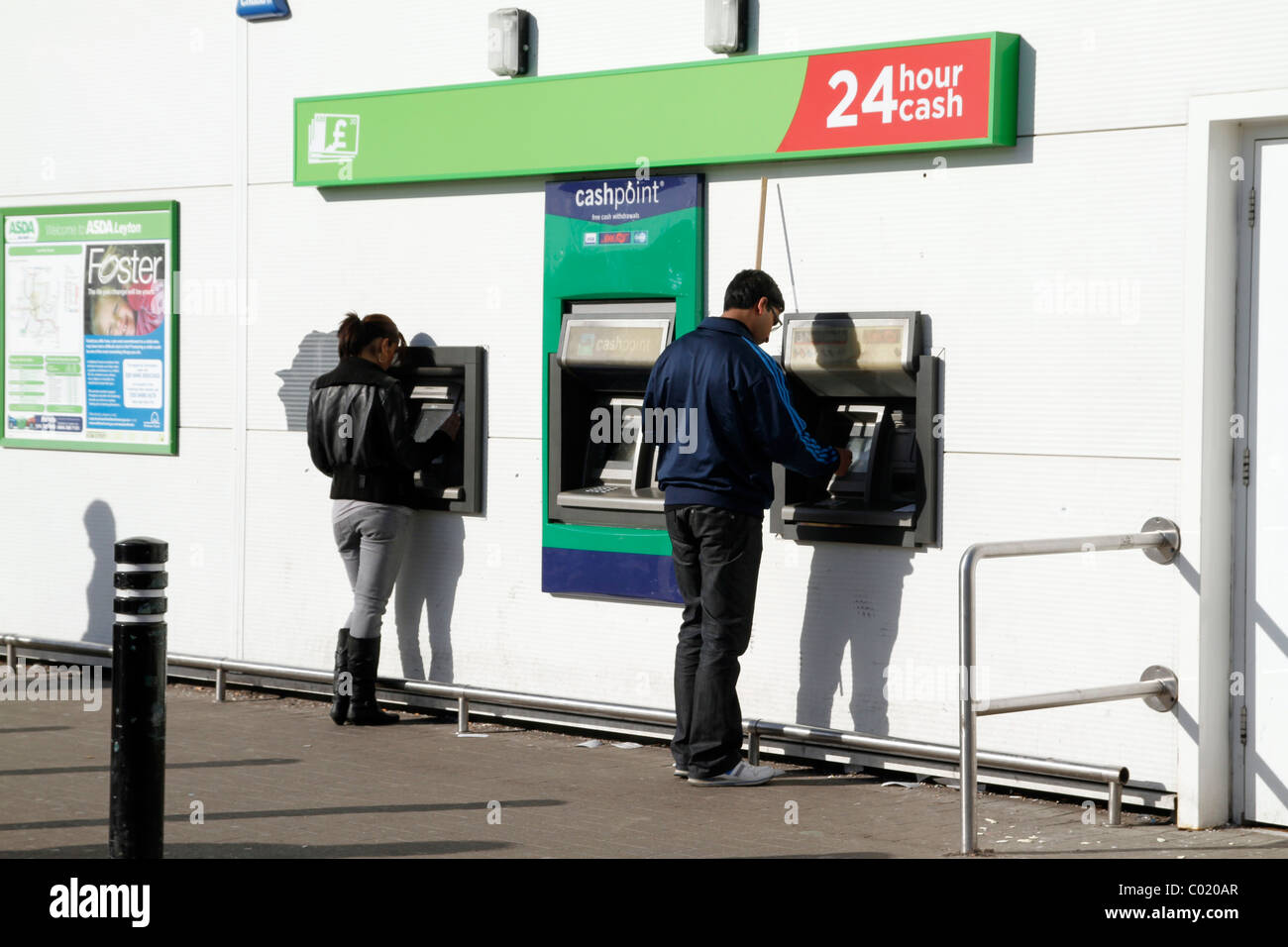 UK. SHOPPERS AT ATM CASH MACHINE OUTSIDE ASDA 24 HOUR SUPERMARKET IN