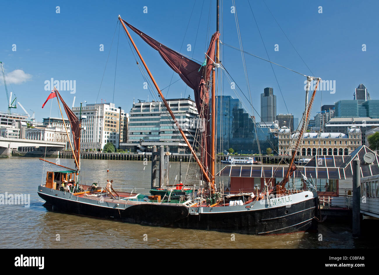 Sailing barge alongside jetty on River Thames (The Thistle), London