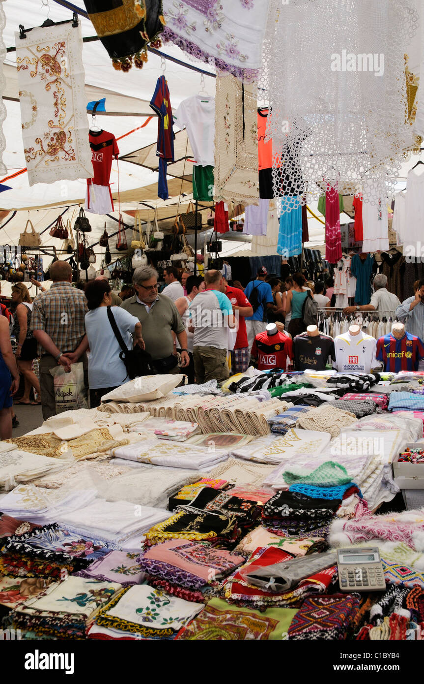 Shopping for clothing in weekly market in the town centre of Stock
