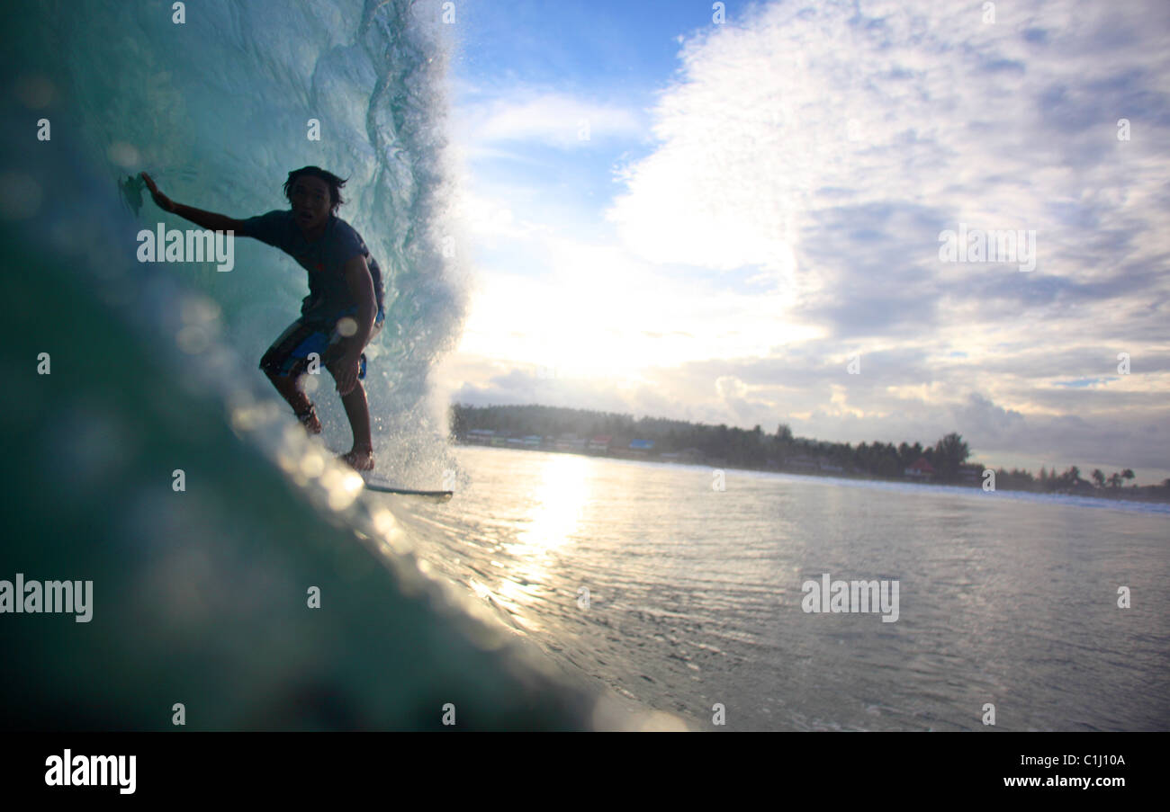 Local Surfer Rides A Lagundri Bay Barrel At Dusk On Nias Island