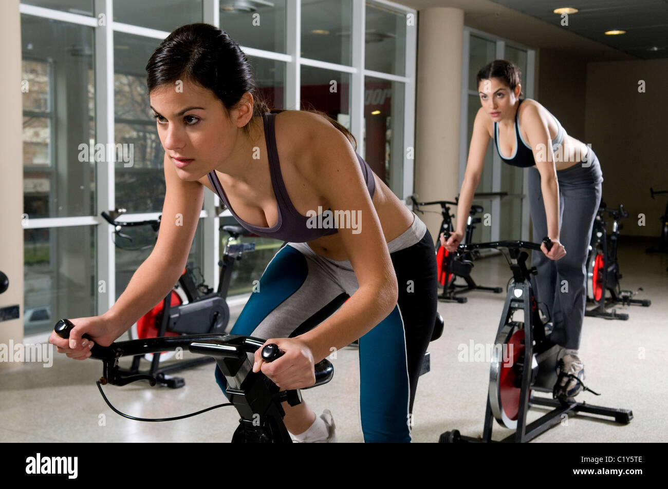 Two Woman Looking At The Camera Sit Sited On A Cycling in cycling gym intended for Property