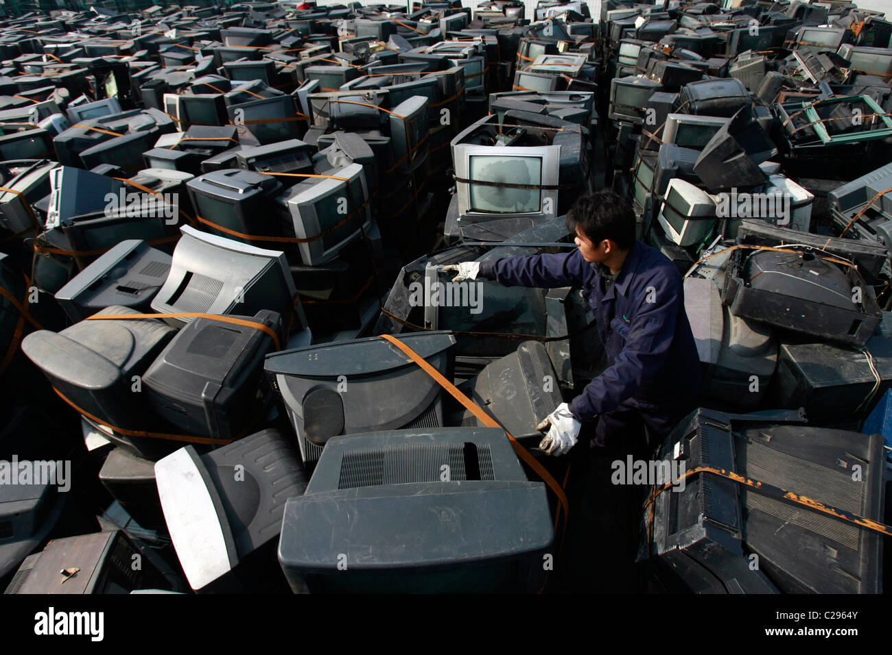 TV recycling centre Workers stack hundreds of used TVs at a recycling