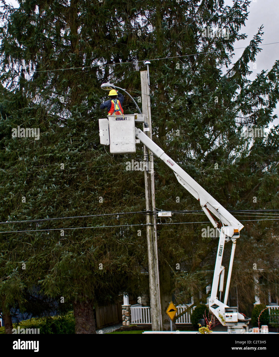Electrician working on a street light in a cherry picker (also known