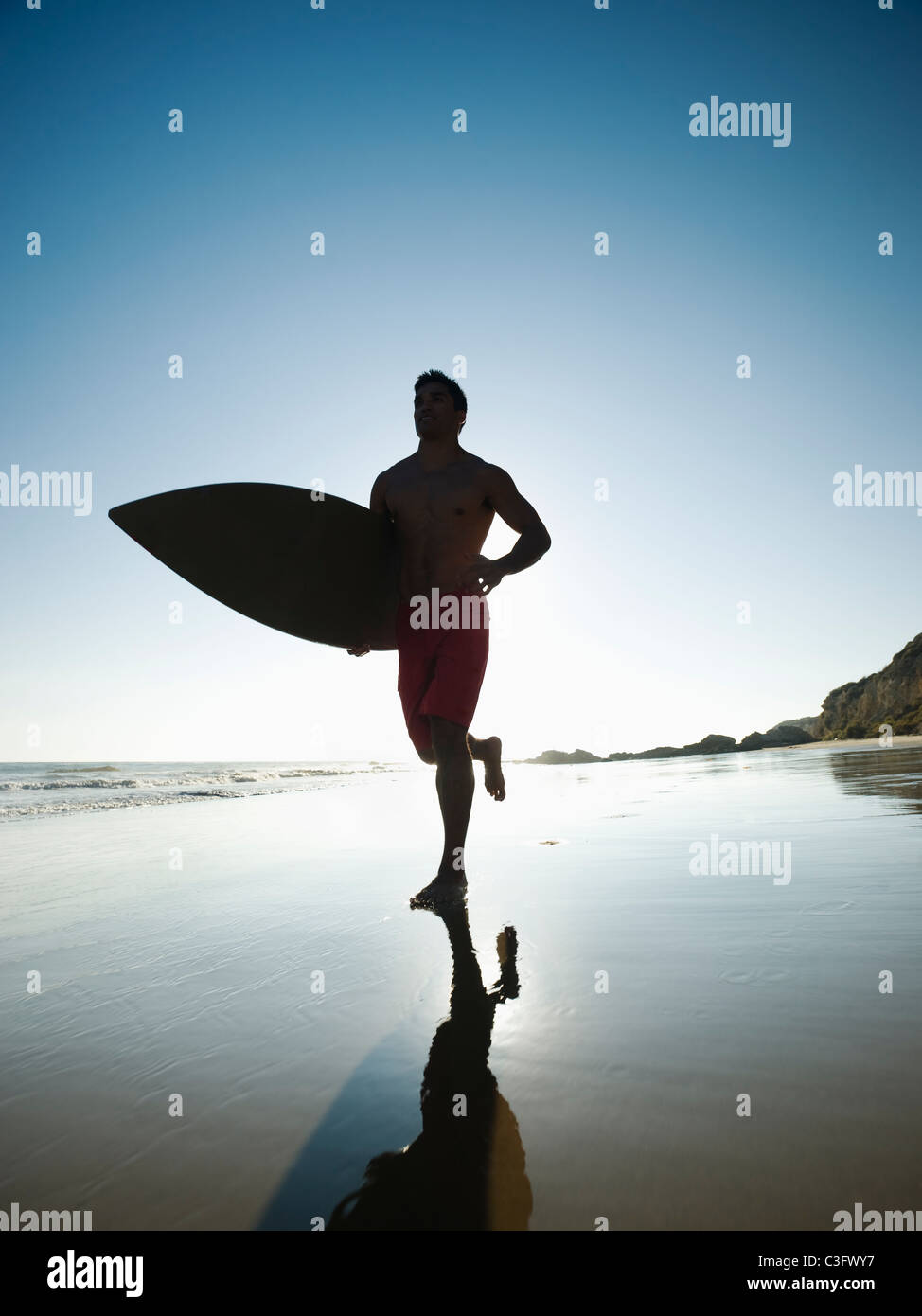 Mixed Race Man Carrying Surfboard On Beach Stock Photo Alamy