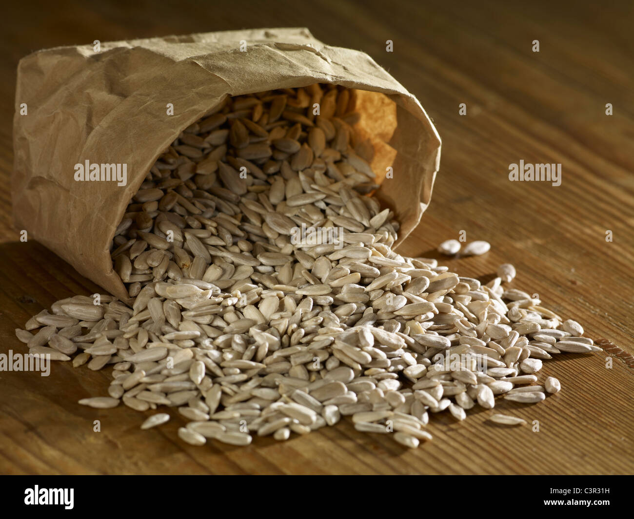 sunflower seeds spilling on wooden surface stock photo sunflower seeds spilling on wooden surface stock photo