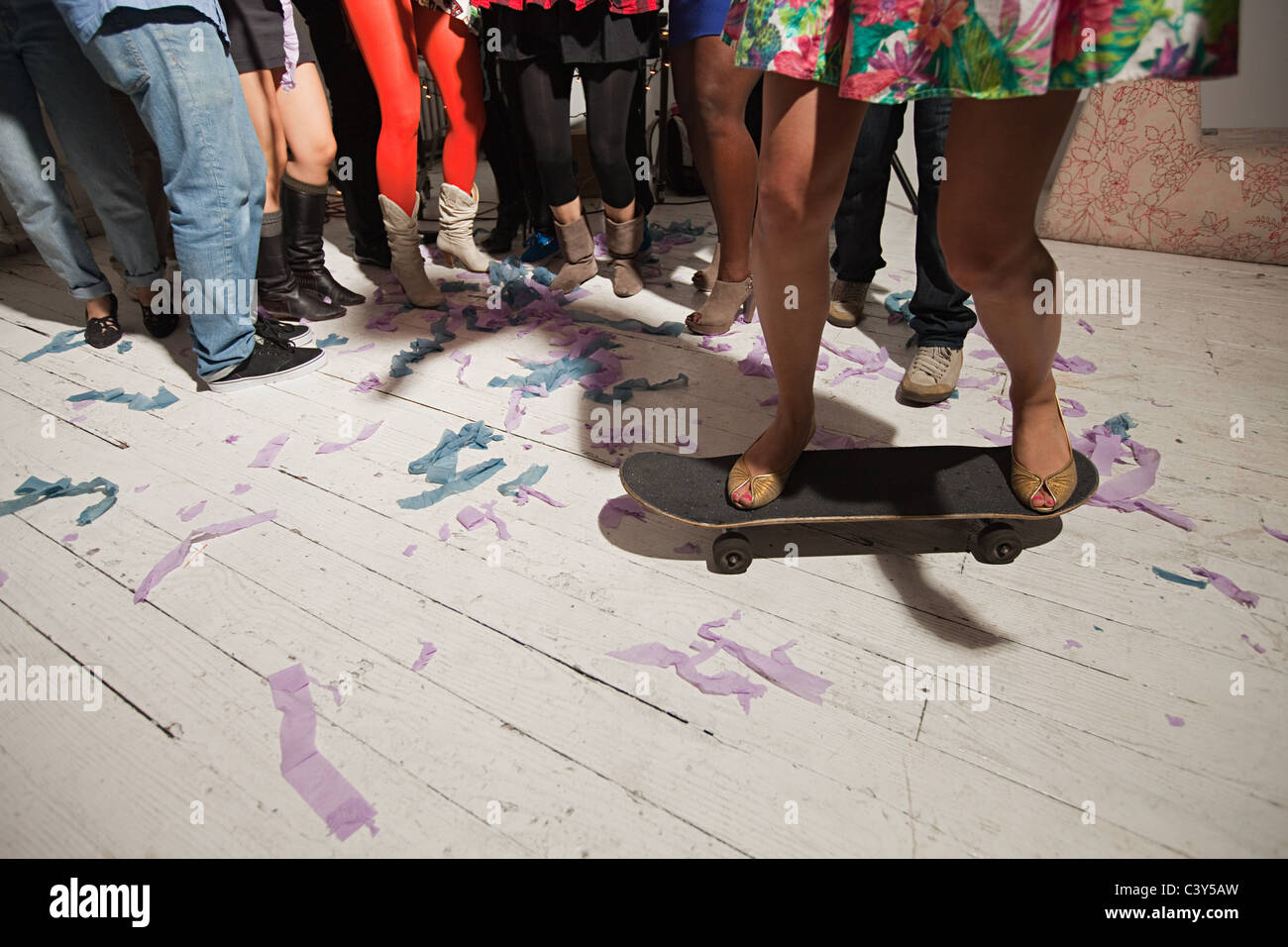 Woman_standing_on_skateboard_at_party-C3