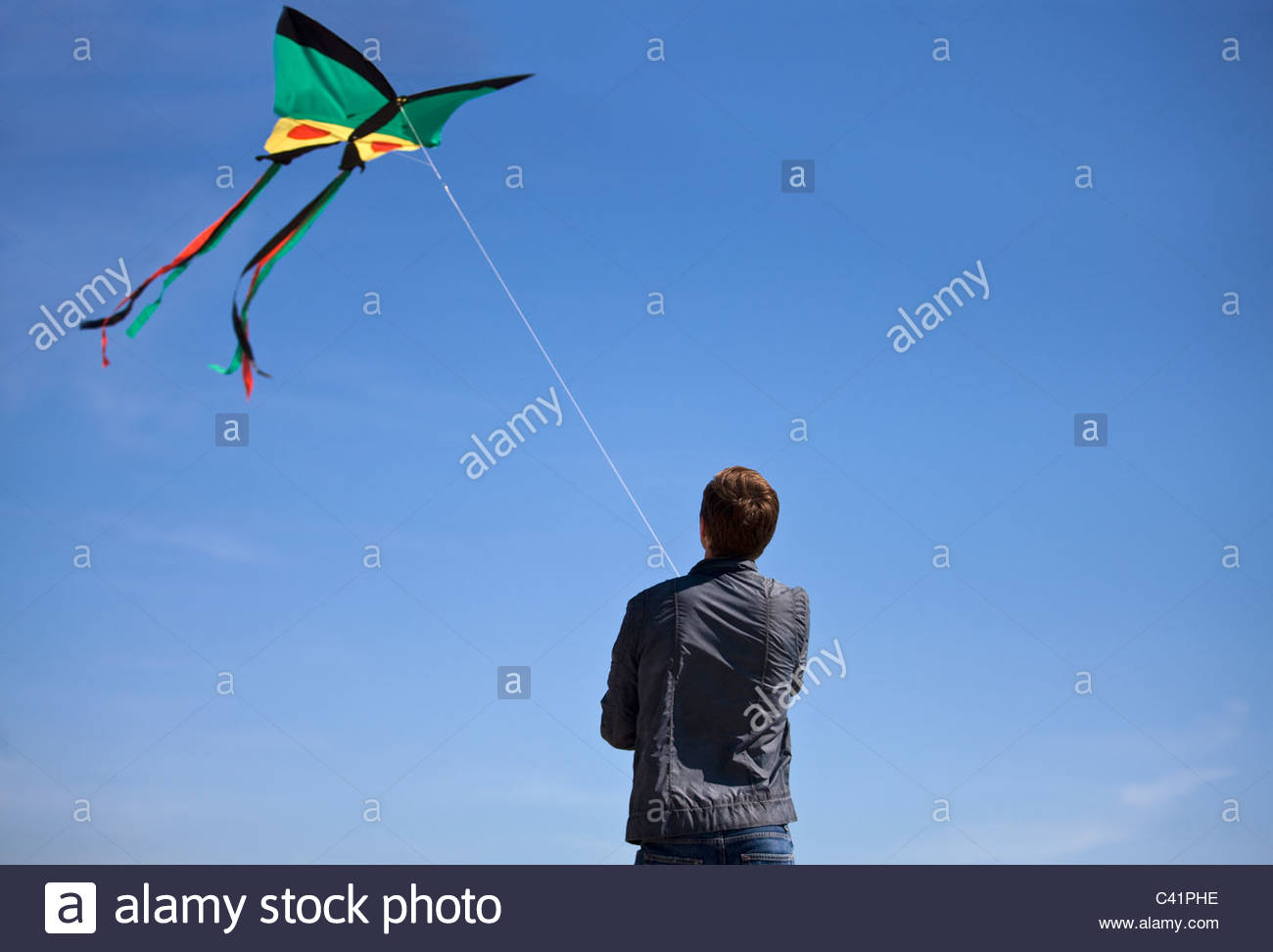 A young man flying a kite on the beach Stock Photo, Royalty Free Image
