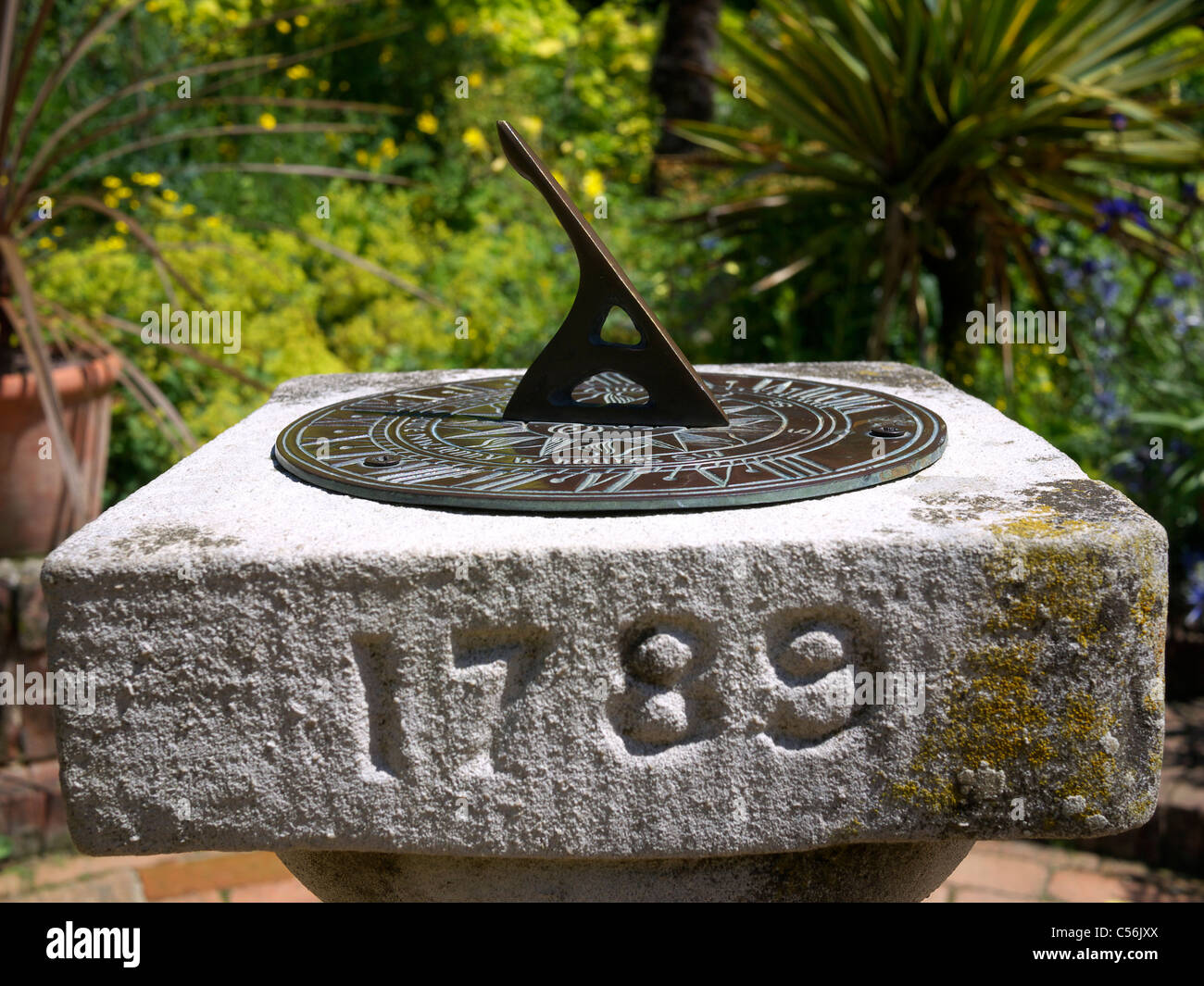 Old sundial on a plinth in a garden setting Stratford UK Stock Photo