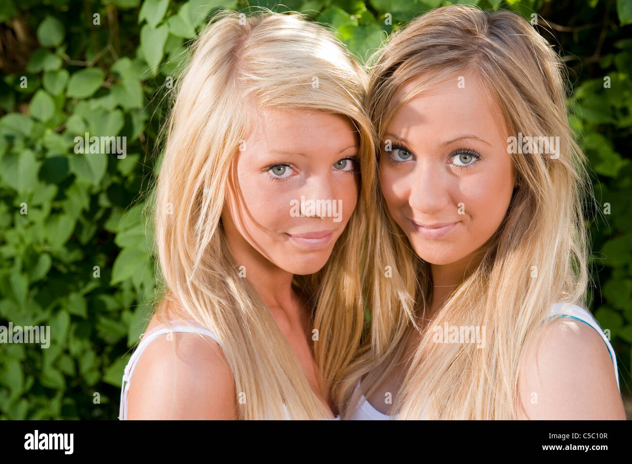 Closeup Portraits Of Two Beautiful Blond Teenage Girls Smiling Stock