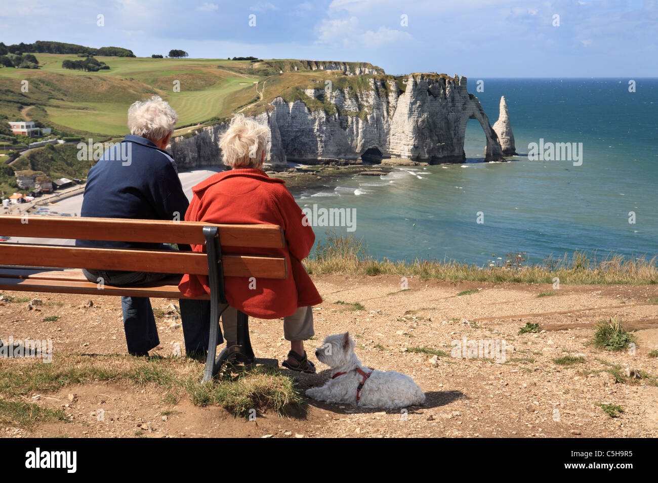 senior-couple-with-dog-sitting-on-bench-