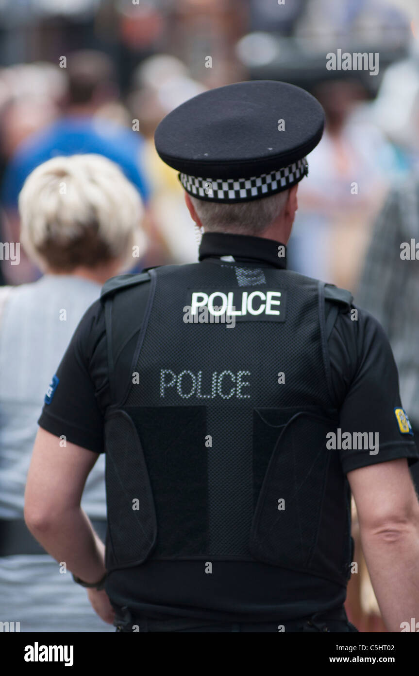 Rear view of a British Police officer wearing a bullet proof vest Stock