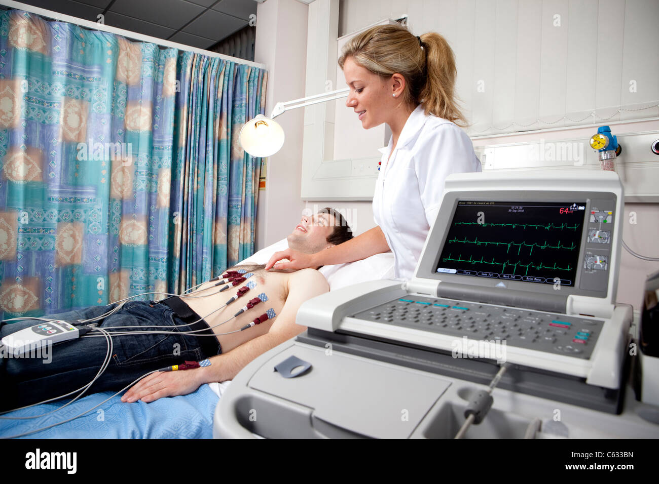 A female cardiologist performs an ECG or electrocardiogram on a young