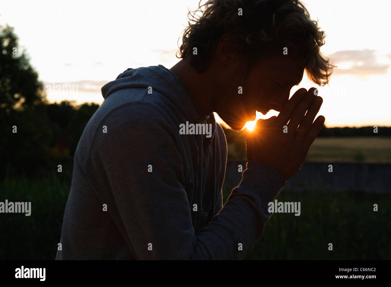 silhouette-of-man-praying-at-sunset-C66N