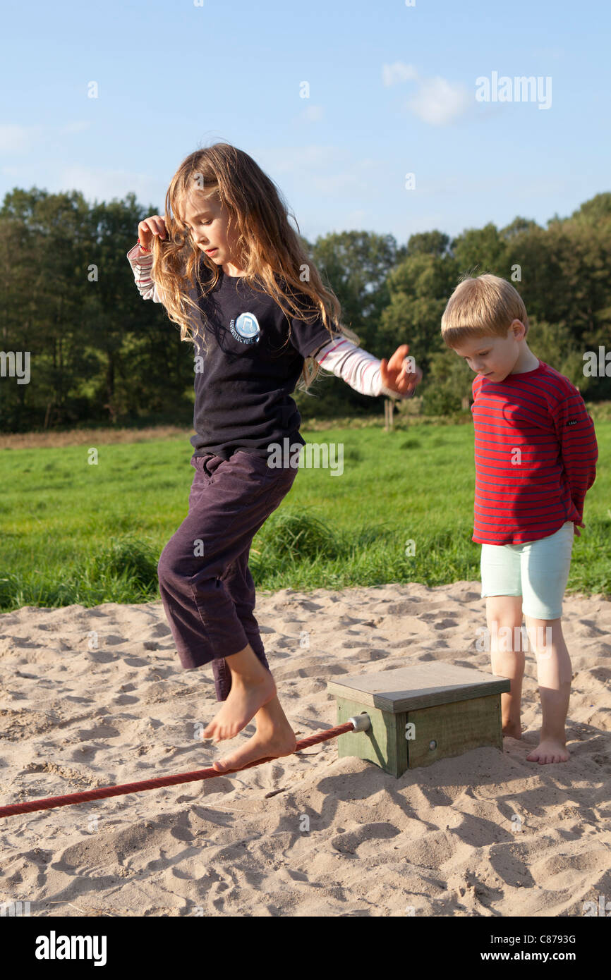 young girl balancing along a rope at barefoot park Egestorf, Luneburg