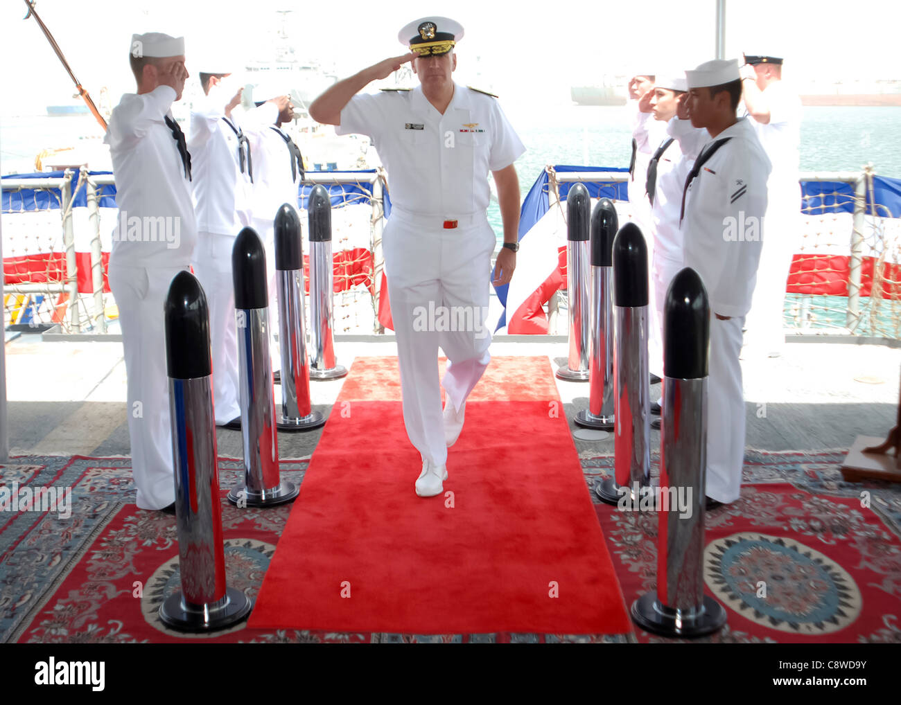 U.S. Navy Rear Adm. Scott Sanders salutes the side boys as he arrives