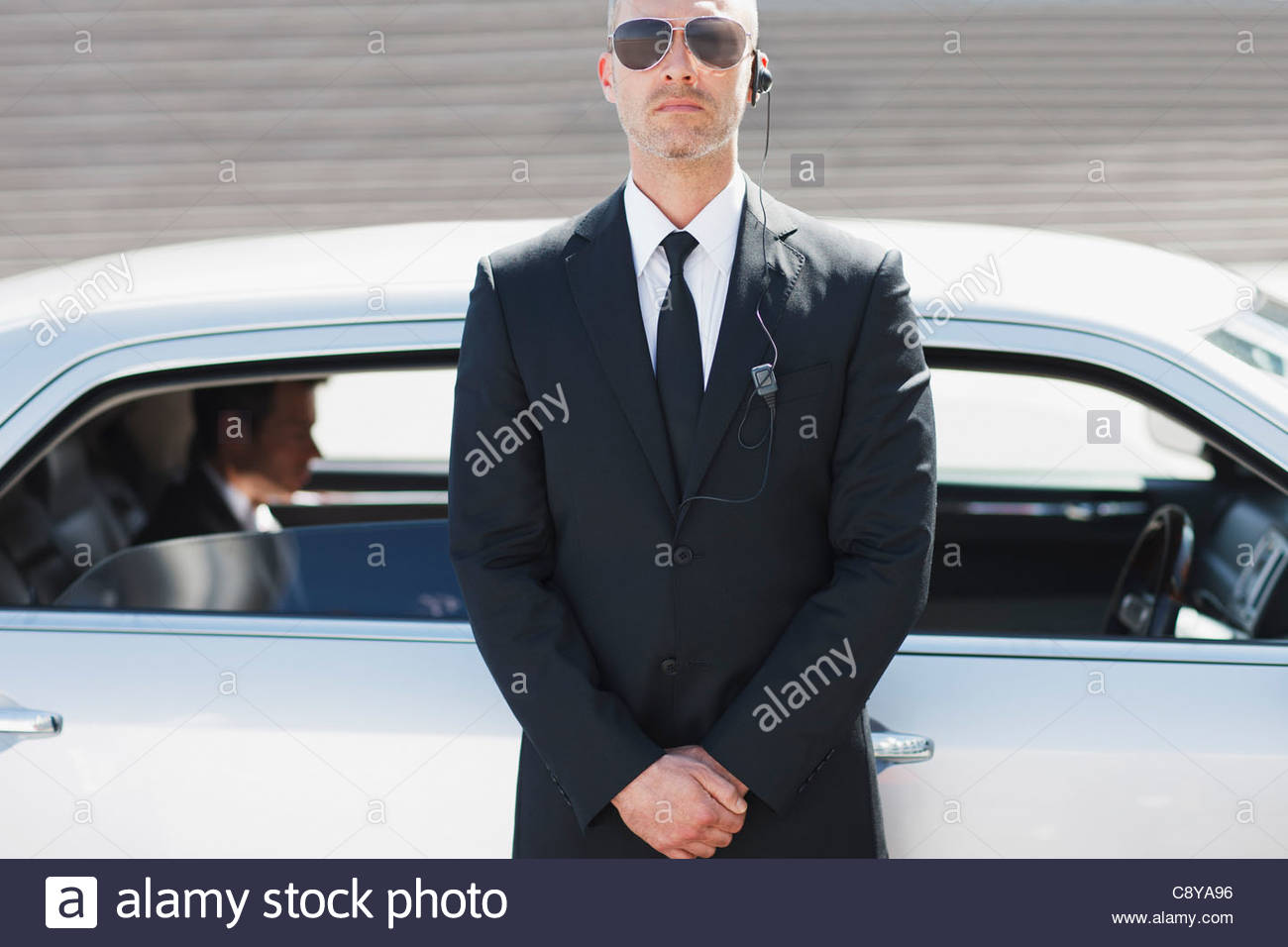 Security guard standing by car Stock Photo, Royalty Free Image