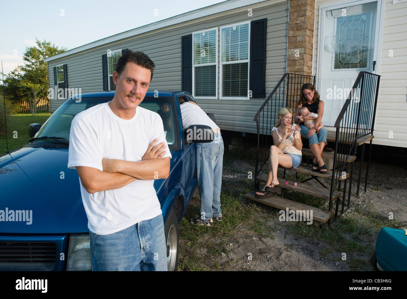 Bluecollar families relaxing in front of a trailer home Stock Photo