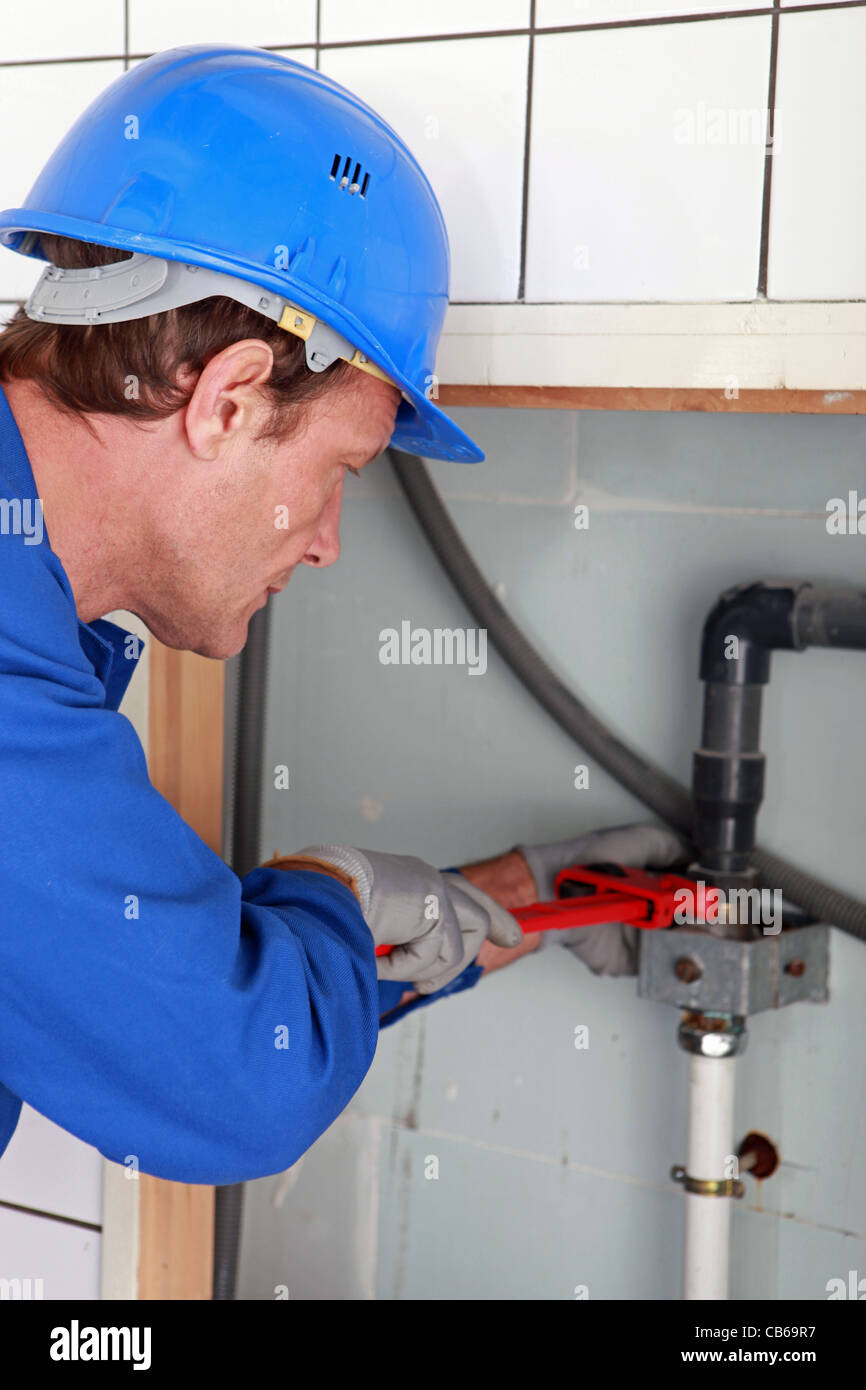 Plumbing tightening a nut with a wrench Stock Photo, Royalty Free Image