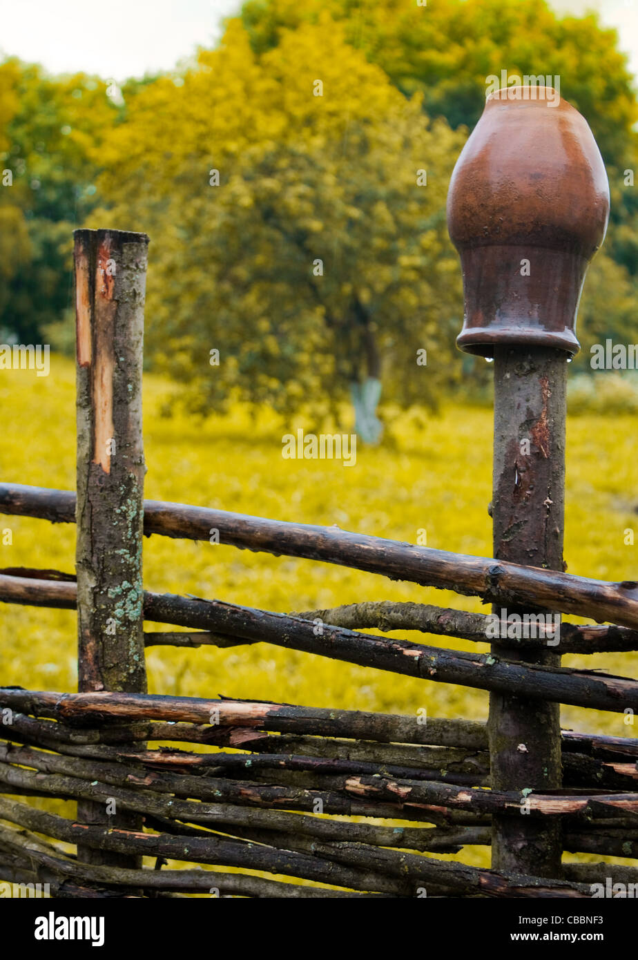 Pot On Wooden Farm Fence With Grass And Tree In Background Stock