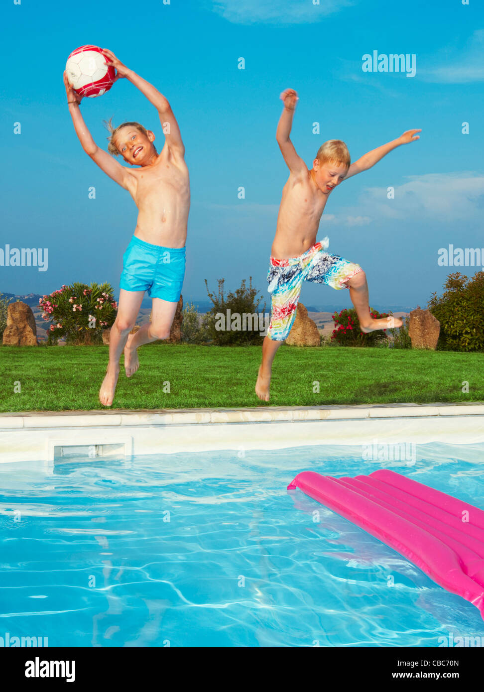 Boys jumping into swimming pool Stock Photo, Royalty Free Image