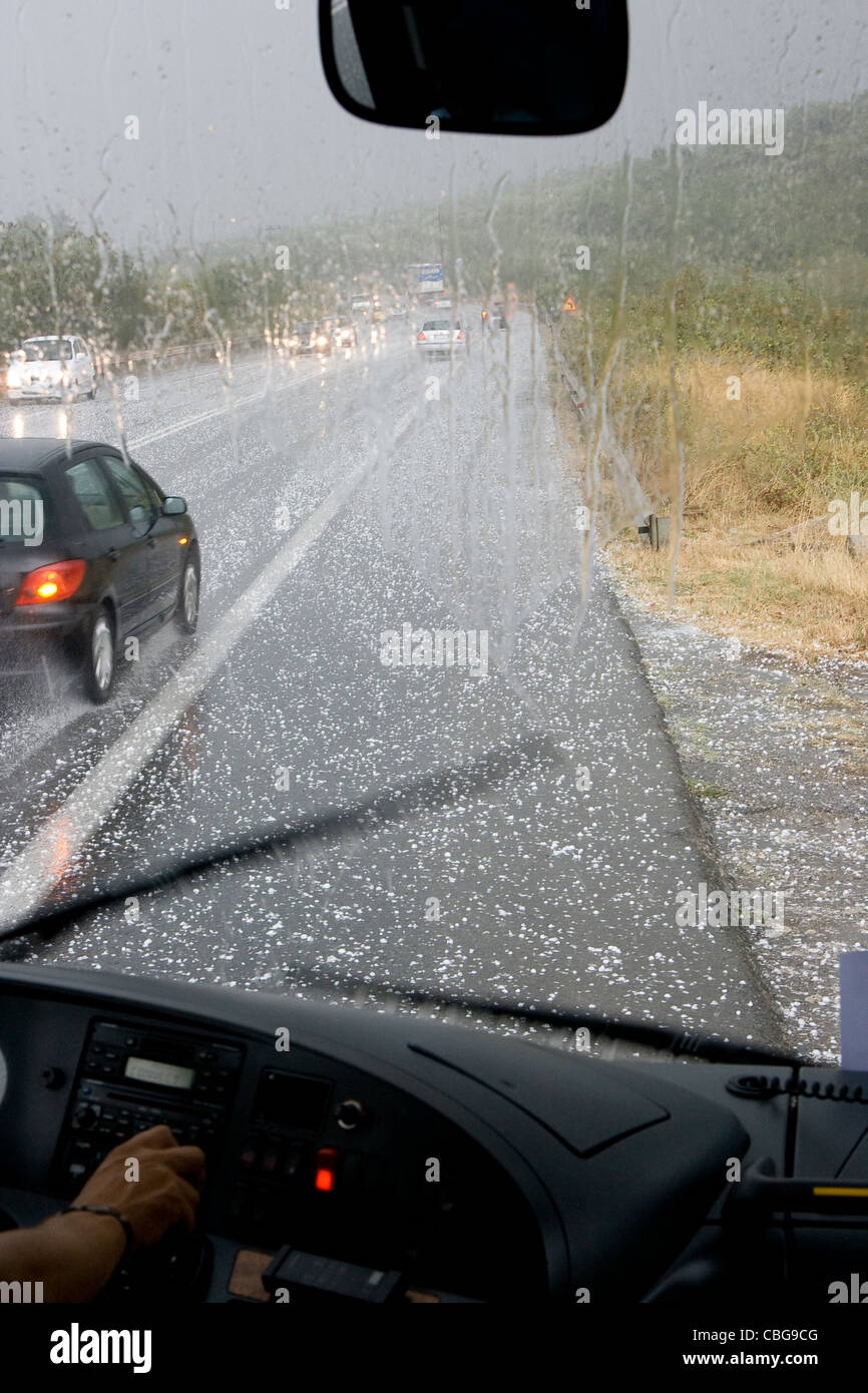 driving in a dangerous road during a hail storm in Greece Stock Photo