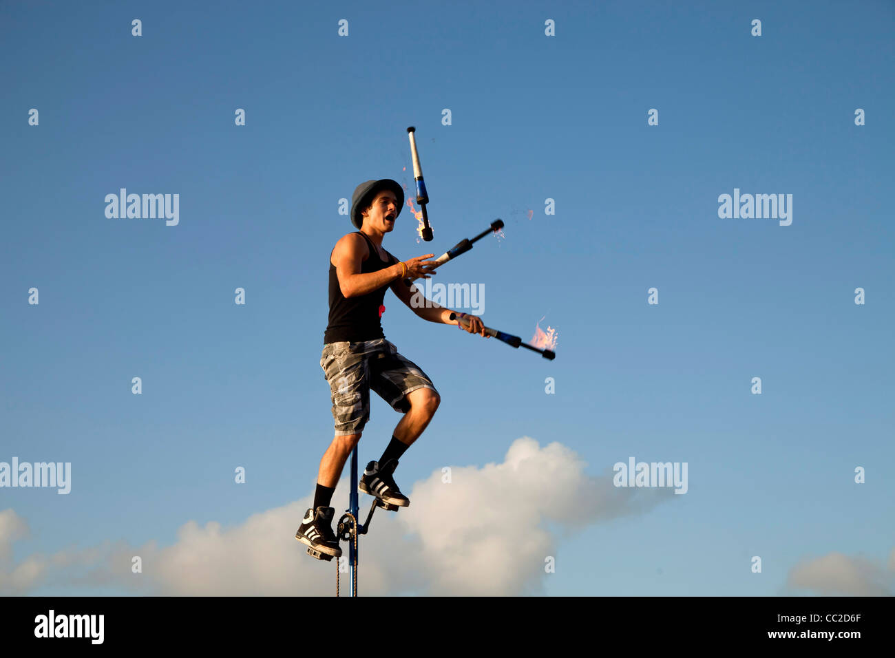 Street performer on Unicycle juggling with torch at Mallory Square in