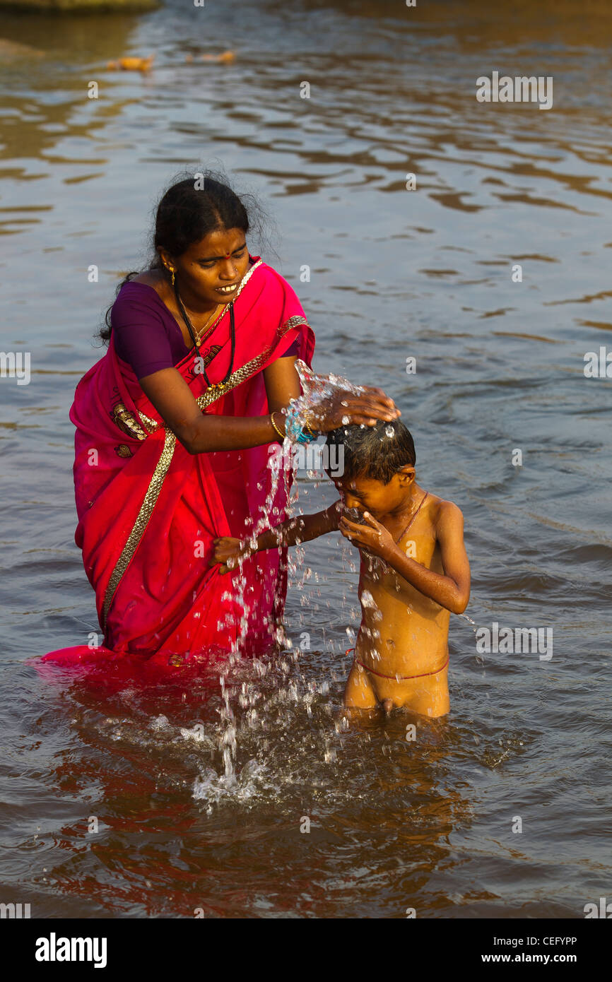 Indian Mother Bathing His Son On The Waters Of Tungabhadra River Stock