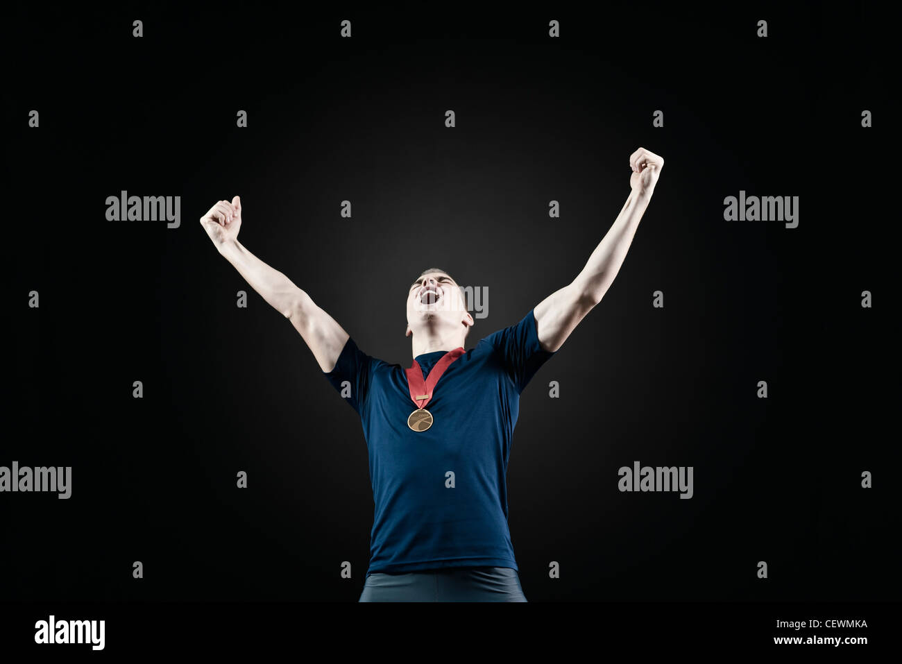 Male Athlete With Arms Raised In Victory Stock Photo