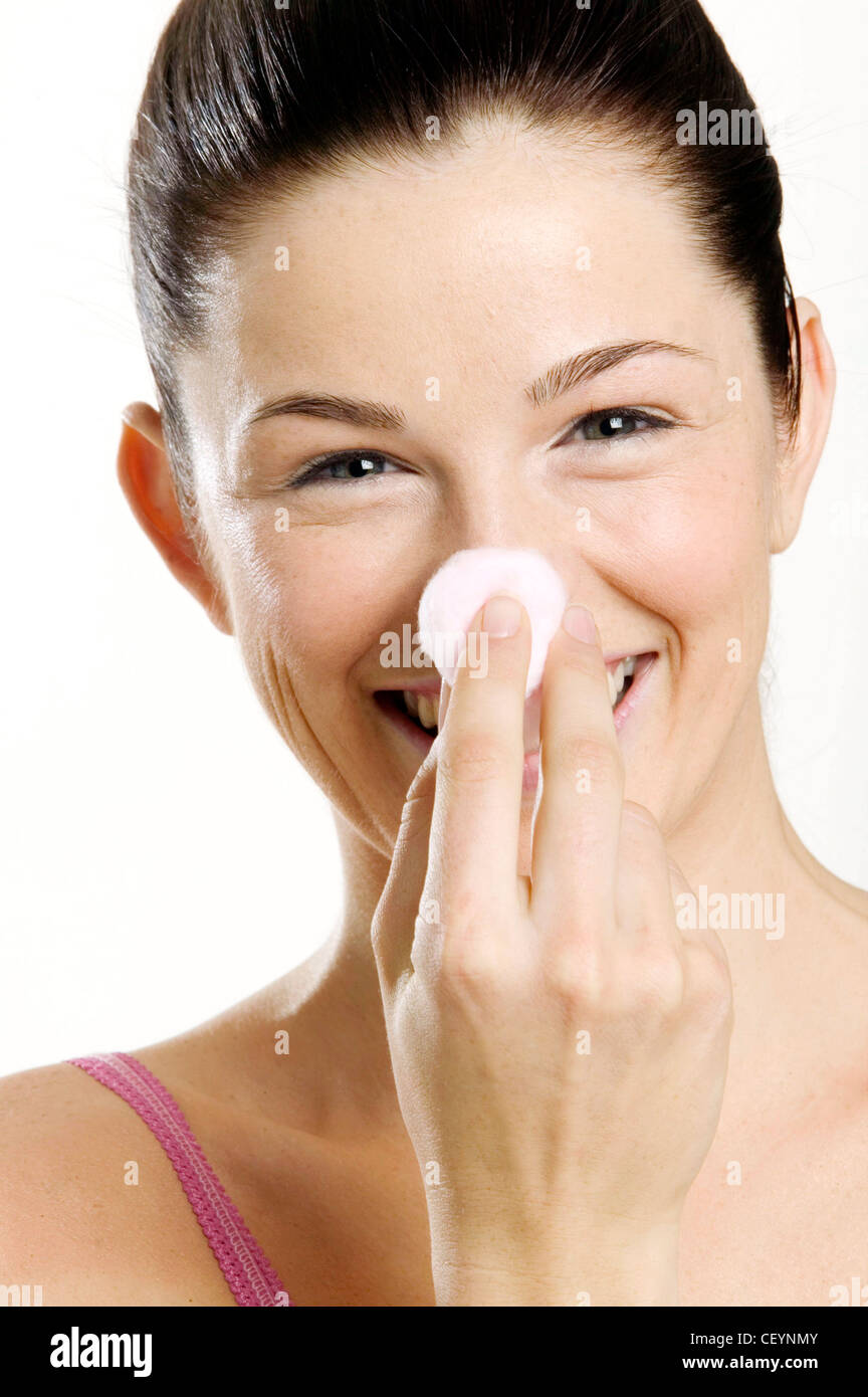 Female With Brunette Hair Off Face Holding Ball Of Cotton Wool To Nose