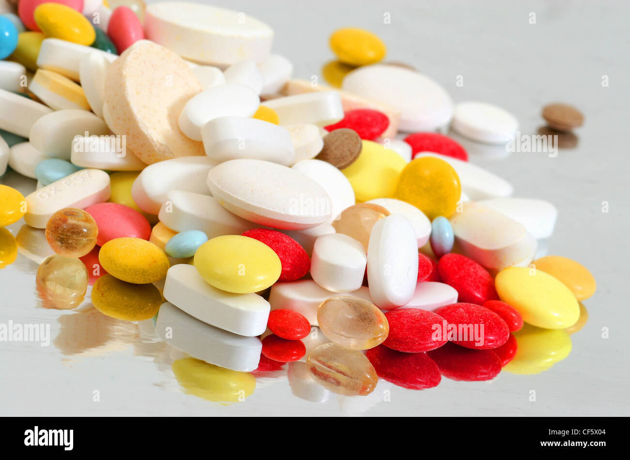 A pile of various tablets, capsules and liquid capsules including Stock
