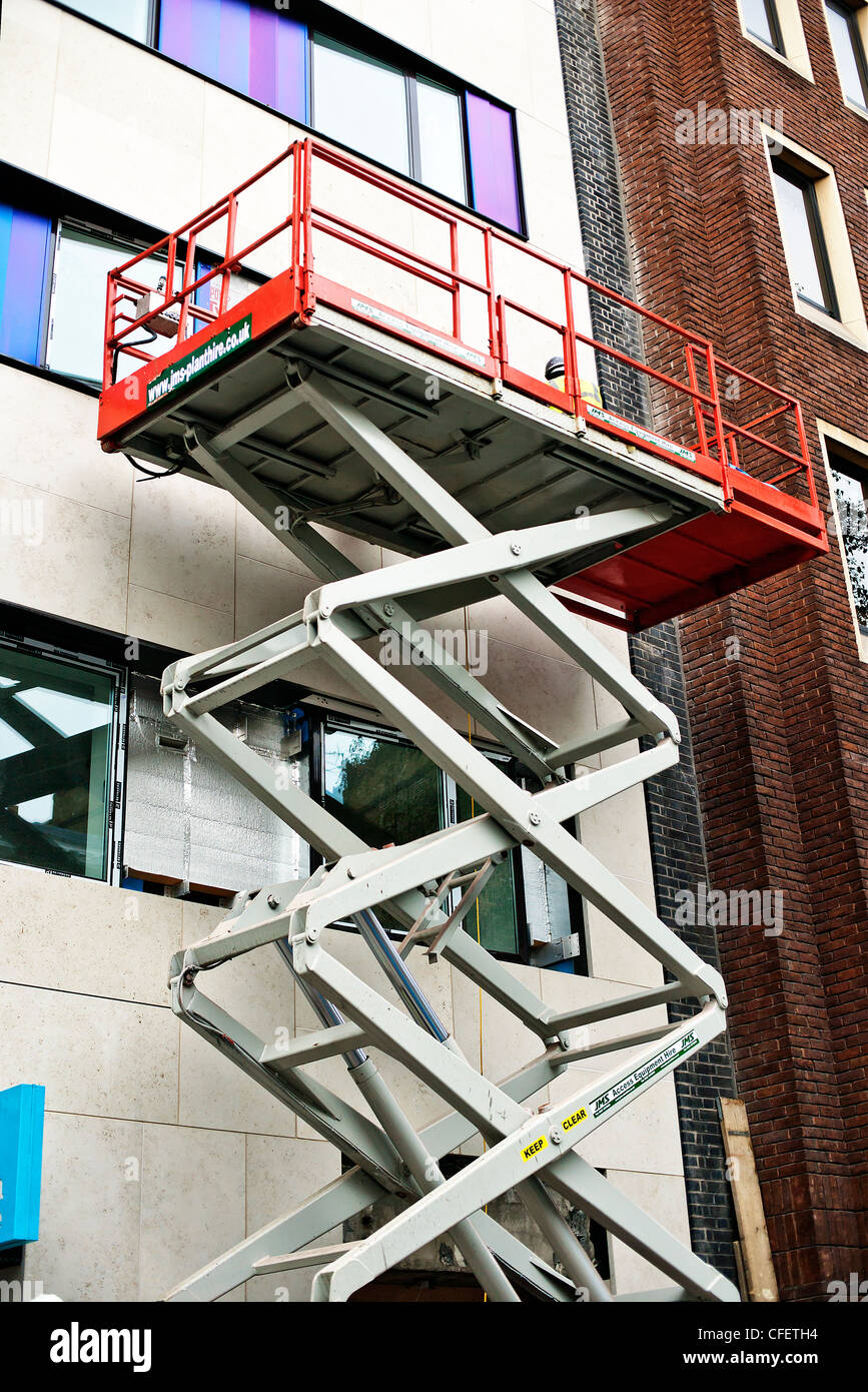 Mobile elevating work platform in use on external building Stock Photo