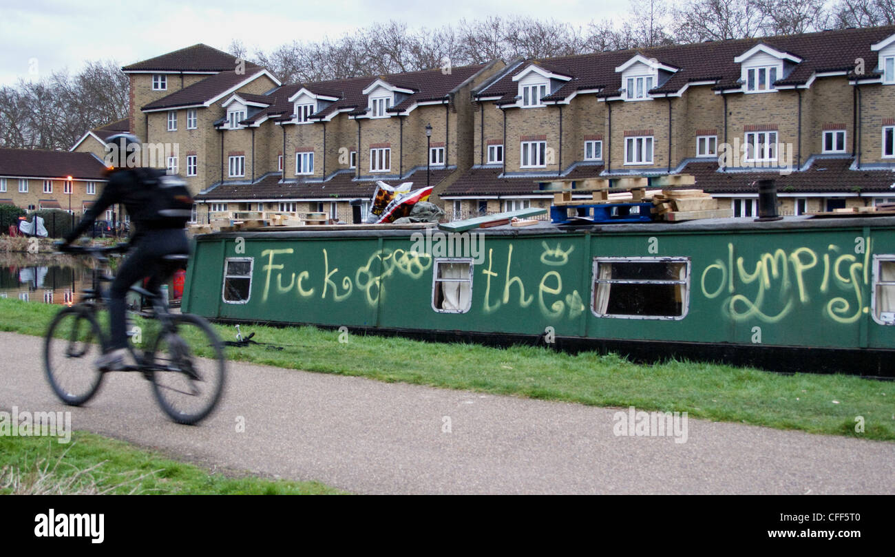 a-cyclist-passes-graffiti-on-narrowboat-