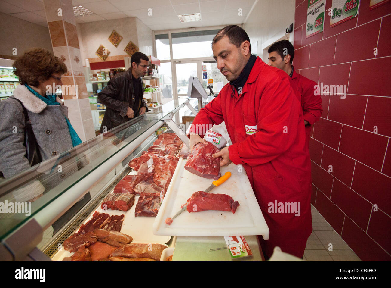 A butcher serves a customer Halal meat at a Halal supermarket in Stock Photo, Royalty Free Image