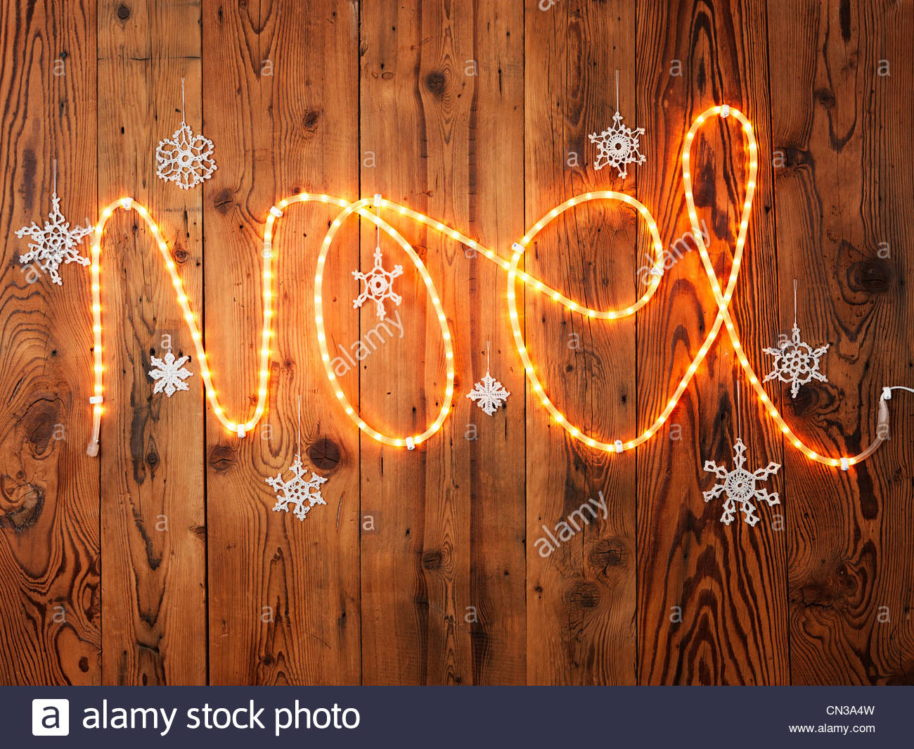 Christmas lights spelling Noel against wood panelling Stock Photo